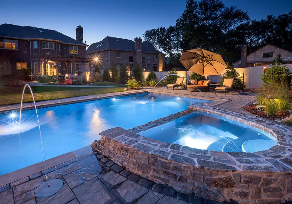 Automated pool and spa with lights and water features at dusk in Paradise Valley