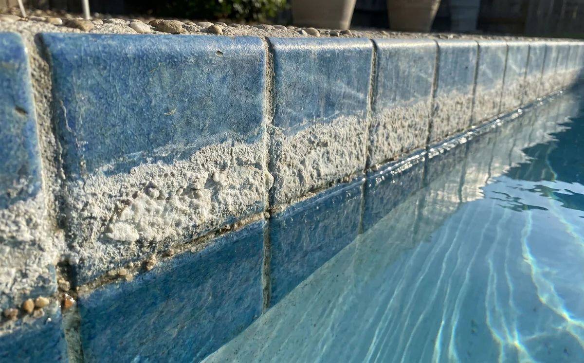 White calcium scale buildup on pool waterline tile in Scottsdale AZ